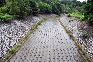 ダムからオーバーフローした水が流れる水路はびっしりとブロックが敷き詰められている。