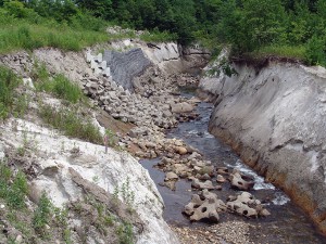 砂防ダム下流の布団カゴとおびただしい数のコンクリートブロック。川底が下がるから、グシャグシャに崩れている。これが、砂利の流下を止める砂防ダムの影響そのものなのである。科学者と言われる人たちは、上流から砂利を供給する視点は持たない。川を固める方向でしか考えないし、議論しようともしない。生物多様な自然環境を損なうばかりか、川底が下がれば地下水が抜かれ水不足が生じ、多くの水産資源を育む川の仕組みそのものを破壊するばかりである。こうした川を破壊するダムそのものも、それを補う場当たりの工事もすべて私たちの税金で行われている。2004年6月20日